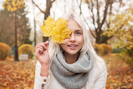 young woman holding autumn leaf