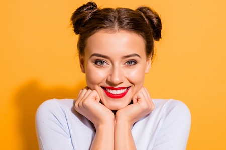 woman smiling with red lipstick and yellow background